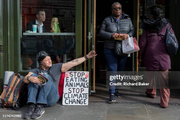 Food science protester sits outside a McDonalds restaurant in Whitehall during the environmental protest about Climate Change occupation of Trafalgar...