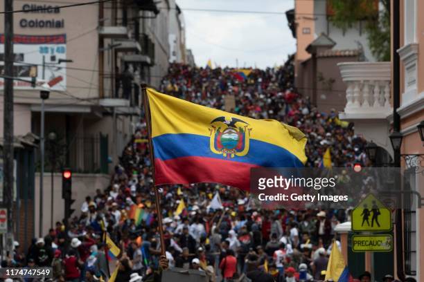 Demonstrator waves an Ecuadorian flag near the Presidential Palace of Carondelet during protests against the end of subsidies to gasoline and diesel...
