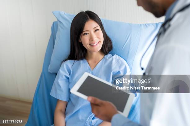 doctor using digital tablet talking with patient. - allergy doctor stockfoto's en -beelden