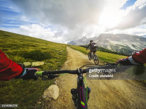 punto di vista pov mountain bike sulle dolomiti - punto di vista del guidatore foto e immagini stock