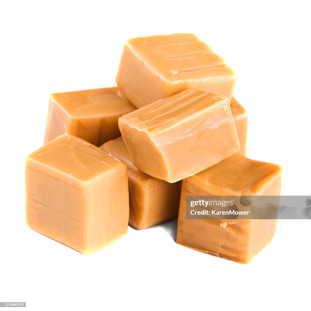 Stack of caramel squares over a white background