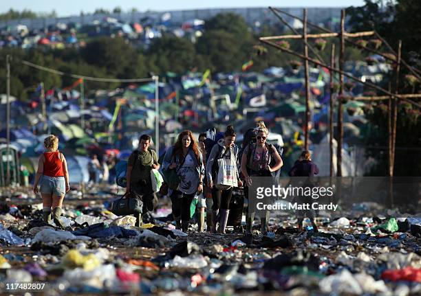 Festival goers walk through rubbish as they begin to leave the Glastonbury Festival site at Worthy Farm, Pilton on June 27, 2011. This year's...