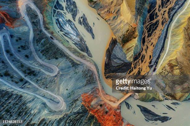 mining truck driving down winding dirt road to the bottom of a canyon - mining from above stock-fotos und bilder