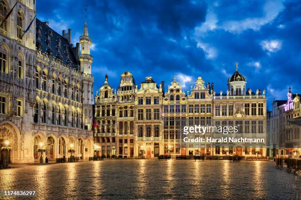 guildhalls on grote markt illuminated at night, grand place, brussels, belgium - expensive statue stockfoto's en -beelden