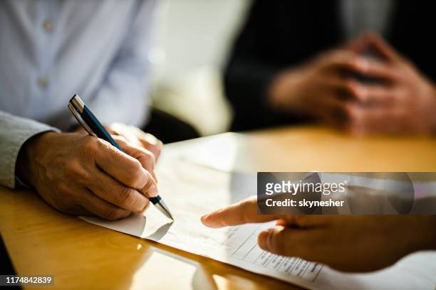 close-up van onherkenbaar persoon die een contract ondertekent. - contract stockfoto's en -beelden
