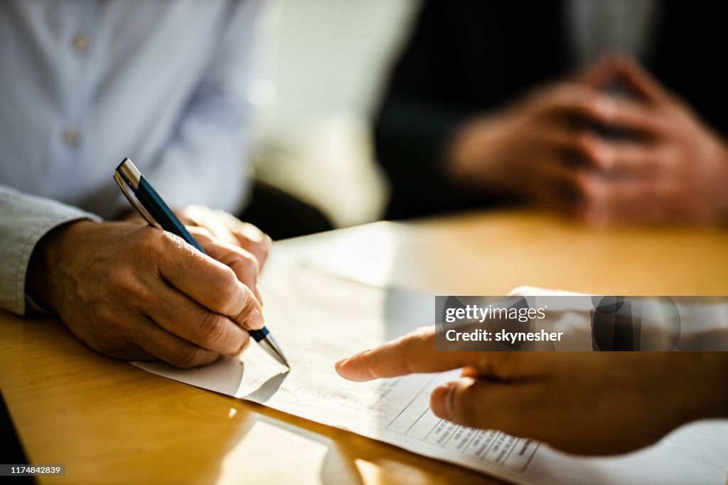 Close up of unrecognizable person signing a contract.