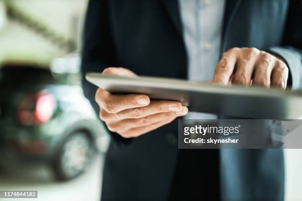 nahaufnahme von nicht erkennbaren autoverkäufer mit digitalen tablet. - autohändler stock-fotos und bilder