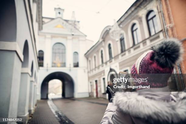 teenage girl making photos the gate of dawn in vilnius, lithuania - vilnius street stock pictures, royalty-free photos & images