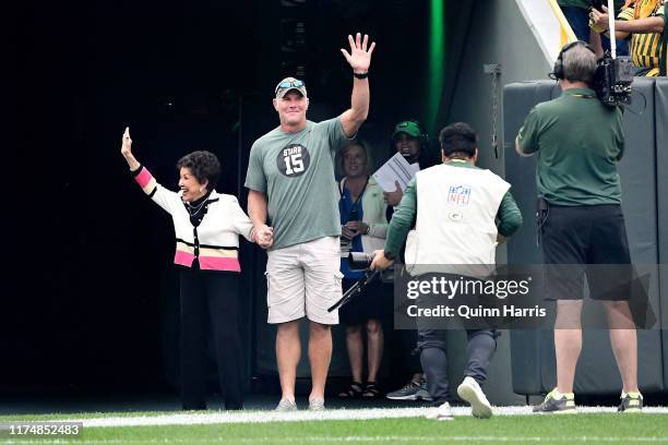 Cherry Louise Morton, wife of Bart Starr, and Brett Favre wave to the crowd before the game between the Minnesota Vikings and Green Bay Packers at...