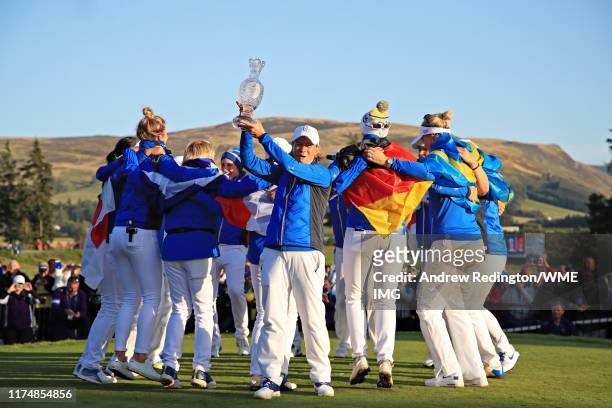 Team Europe captain Catriona Matthew holds the Solheim Cup as Team Europe celebrate winning the tournament behind during the final day singles...