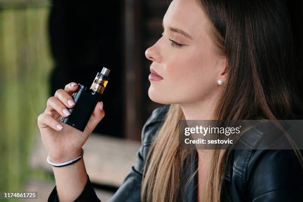 closeup of woman smoking electronic cigarette - vaping danger stock pictures, royalty-free photos & images