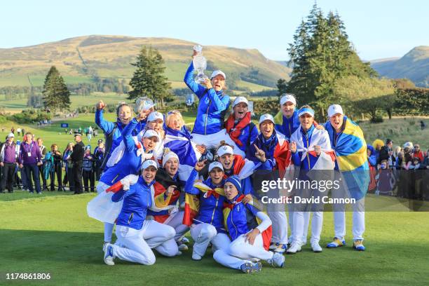 Catriona Matthew the European Team captain is raised high by her team as they pose with teh Solheim Cup after their victory after the final day...