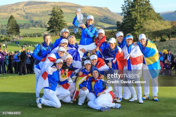 Catriona Matthew the European Team captain is raised high by her team as they pose with teh Solheim Cup after their victory after the final day...