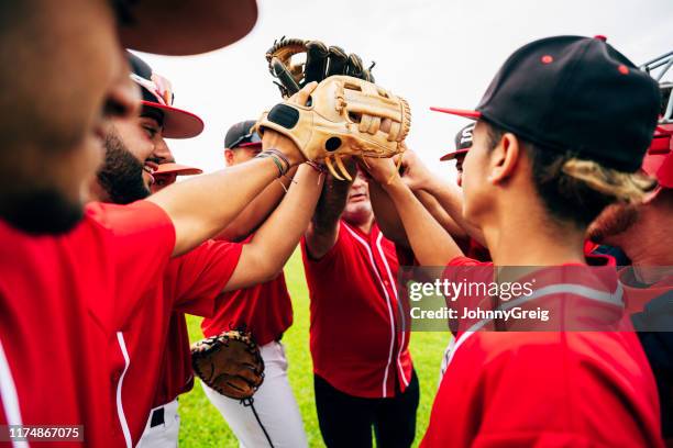 baseball-team-trainer und spieler heben handschuhe für high-five - baseball sport stock-fotos und bilder