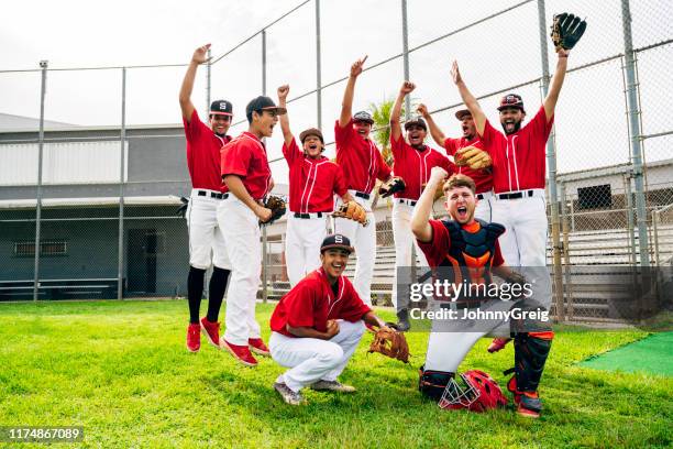 compañeros de equipo de béisbol hispanos saltando y gesturing en la victoria - baseball strip fotografías e imágenes de stock