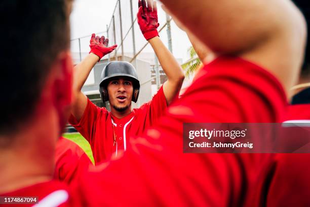 close-up of baseball teammates congratulating scoring player - sports team high five stock pictures, royalty-free photos & images