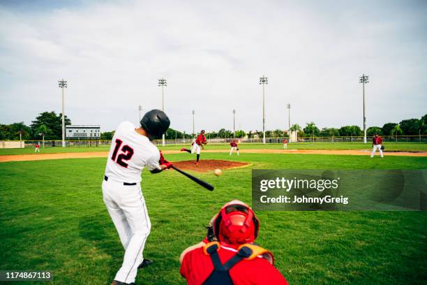jonge honkbal speler swingende zijn vleermuis op gegooid pitch - baseball equipment stockfoto's en -beelden