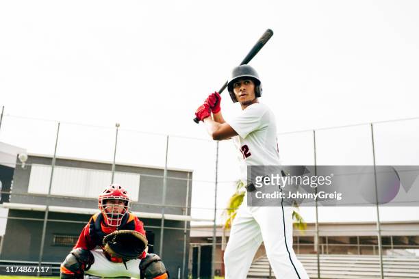 Hispanic baseball batter and catcher waiting for pitch