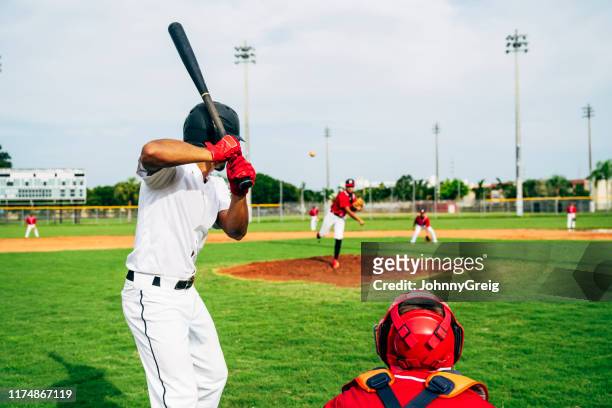 rear view of baseball batter and catcher watching the pitch - batter imagens e fotografias de stock