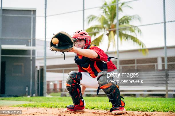 baseballfänger kauert, um pitch in der mitte der mitt zu fangen - baseballfänger stock-fotos und bilder