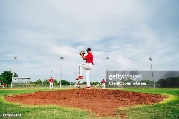 young hispanic baseball pitcher in wind-up position - arremessar imagens e fotografias de stock