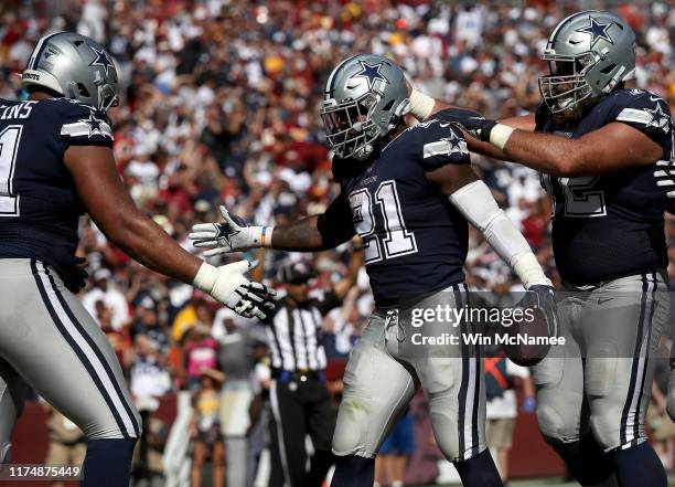 Running back Ezekiel Elliott of the Dallas Cowboys celebrates with teammates after crossing the goal line for a touchdown during second half action...