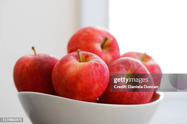 apples on a bowl - fruit bowl stock pictures, royalty-free photos & images