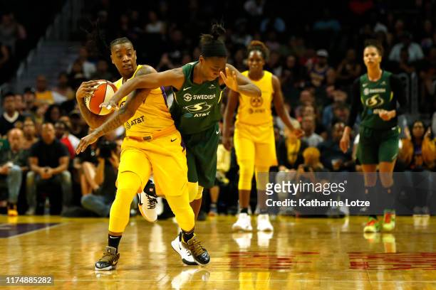 Guard Riquna Williams of the Los Angeles Sparks and guard Jewell Loyd of the Seattle Storm fight for a jump ball during the second half of Seattle...