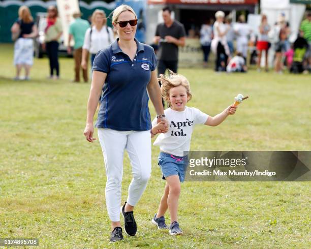 Zara Tindall walks hand in hand with daughter Mia Tindall as they attend day 3 of the Whatley Manor Gatcombe International Horse Trials at Gatcombe...
