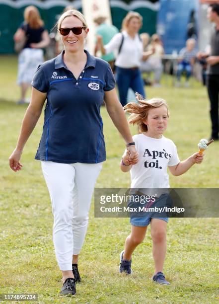 Zara Tindall walks hand in hand with daughter Mia Tindall as they attend day 3 of the Whatley Manor Gatcombe International Horse Trials at Gatcombe...