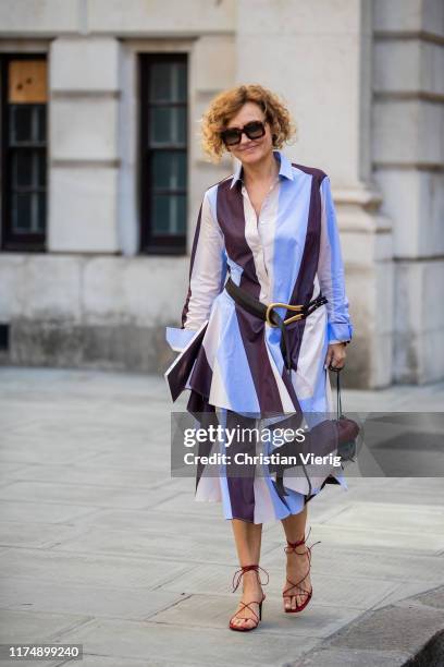 Guest is seen wearing striped dress outside Victoria Beckham during London Fashion Week September 2019 on September 15, 2019 in London, England.