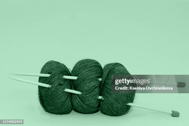 color thread for knitting, knitted scarf, knitting needles on a dark background. copy space. knitting concept - stricknadel stock-fotos und bilder