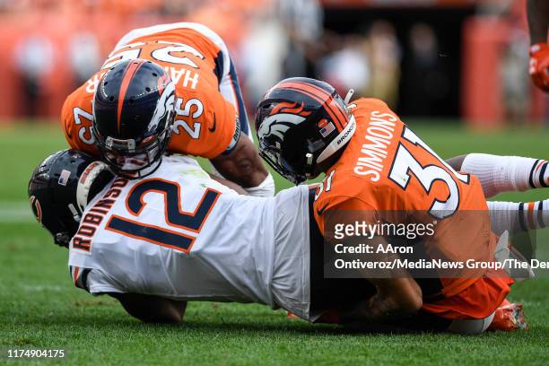 Allen Robinson of the Chicago Bears is tackled by Chris Harris and Justin Simmons of the Denver Broncos during the second half of Chicaco's 16-14 win...