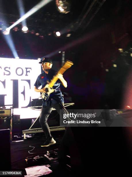 Tom Morello, set list taped to stage before him, runs as he performs with Tim Commerford, Brad Wilk, B-Real, Chuck D, and DJ Lord in Prophets of Rage...