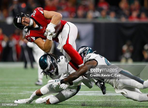 Austin Hooper of the Atlanta Falcons attempts to leap over Sidney Jones as he is tackled by Malcolm Jenkins of the Philadelphia Eagles during the...