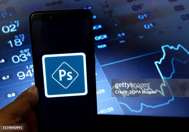 In this photo illustration a popular technology company Adobe Photoshop logo seen being displayed in a smartphone .