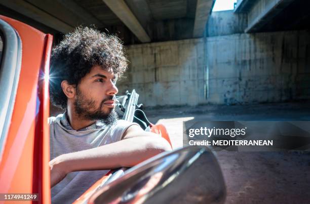 etnische jonge man rijden rode generieke auto convertible - fabolous musician stockfoto's en -beelden
