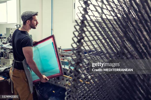 silkscreen serigraphy man printing job - t shirt printing stock pictures, royalty-free photos & images