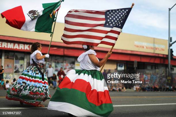 Performers carry the Mexican and U.S. Flags during Santa Ana's annual Fiestas Patrias parade on September 15, 2019 in Santa Ana, California. Fiestas...