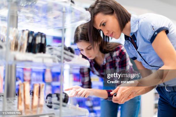 friends shopping for face cream - choosing perfume stock pictures, royalty-free photos & images