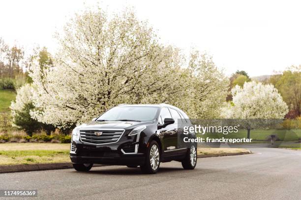 new cadillac xt5 parked on a country road in redding, connecticut - black alley stock pictures, royalty-free photos & images