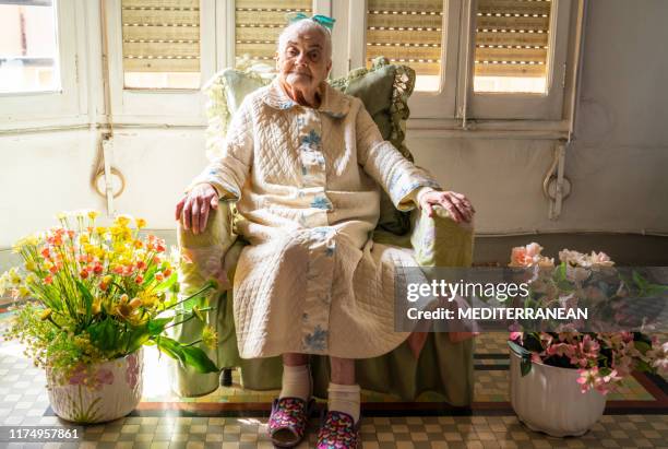 anciana mujer de los 90 se sente en el sillón - 100th anniversary fotografías e imágenes de stock