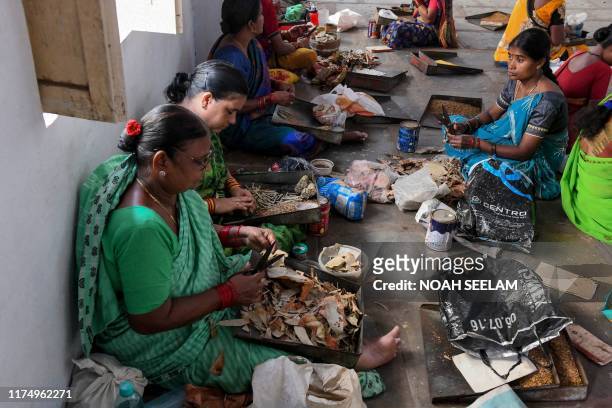 Labourers use a combination of chewing tobacco and tendu leaves to make hand-rolled 'beedi' at a workshop in Nizamabad, some 180 kilometers from...