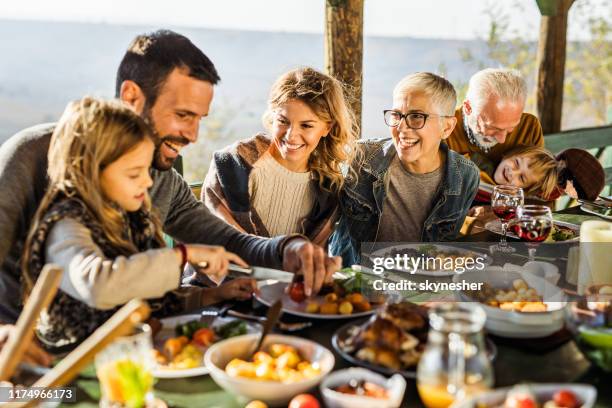 happy extended family having their lunch on a terrace. - family lunch stock pictures, royalty-free photos & images