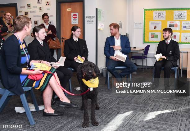 Britain's Prince Harry, Duke of Sussex joins a Reluctant Readers Session, with Barney the therapy dog during his visit to Nottingham Academy on...