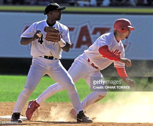 Miguel Tejada stopper for the Aguilas de Cibao of the Dominican Republic gets ready to throw the double play after he put Puerto Rican Luis Lopez...