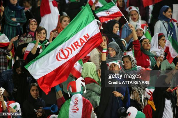 Iranian women cheer ahead of the World Cup Qatar 2022 Group C qualification football match between Iran and Cambodia at the Azadi stadium in the...