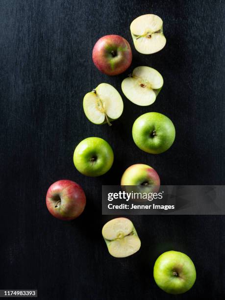 cut and whole fresh apples on a dark background. - corazón de manzana fotografías e imágenes de stock