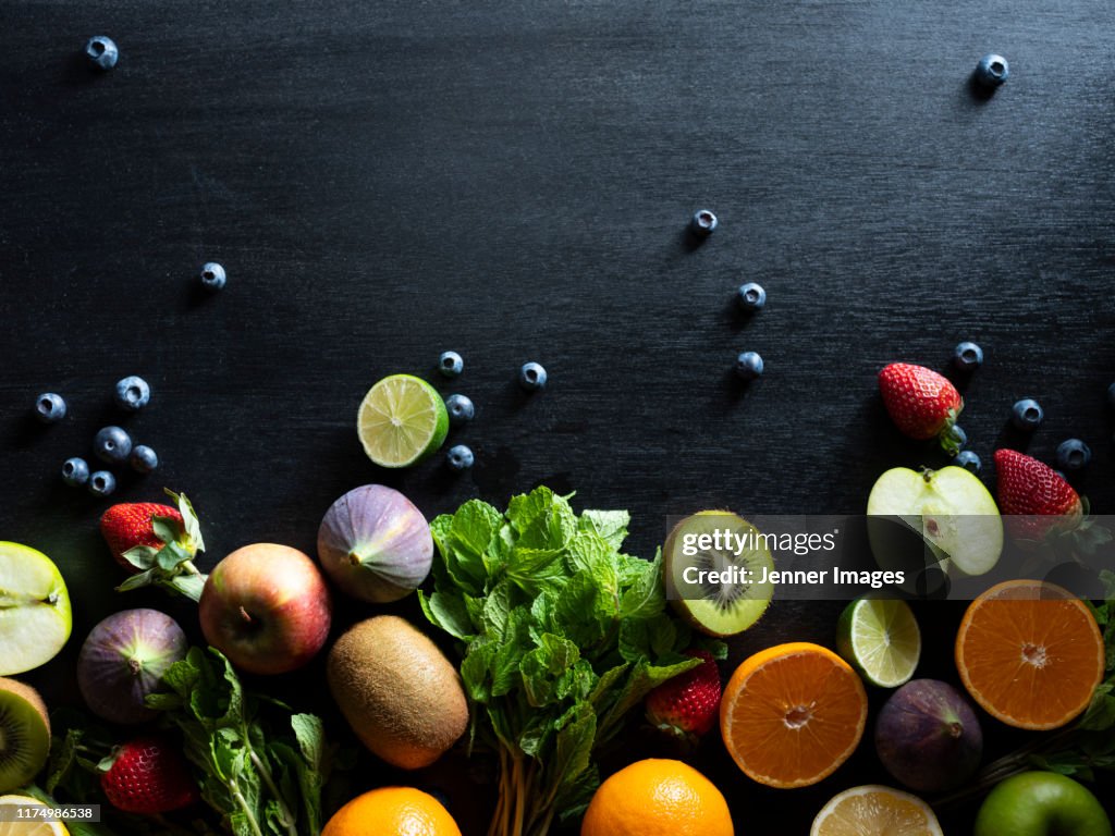 Various Cut And Whole Fruit On Dark Background.