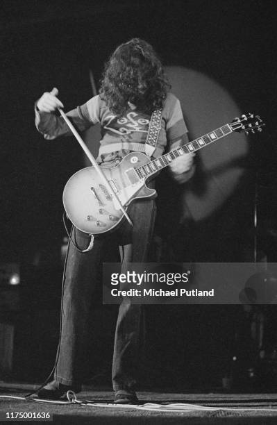 Guitarist Jimmy Page of English rock group Led Zeppelin drags a violin bow over the strings of his Gibson Les Paul Guitar on stage during the...